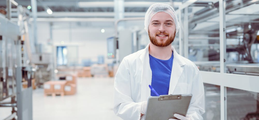 man in hairnet with clipboard in manufacturing setting