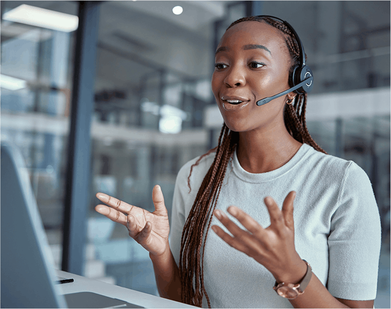 african american woman speaking through a headset at a computer