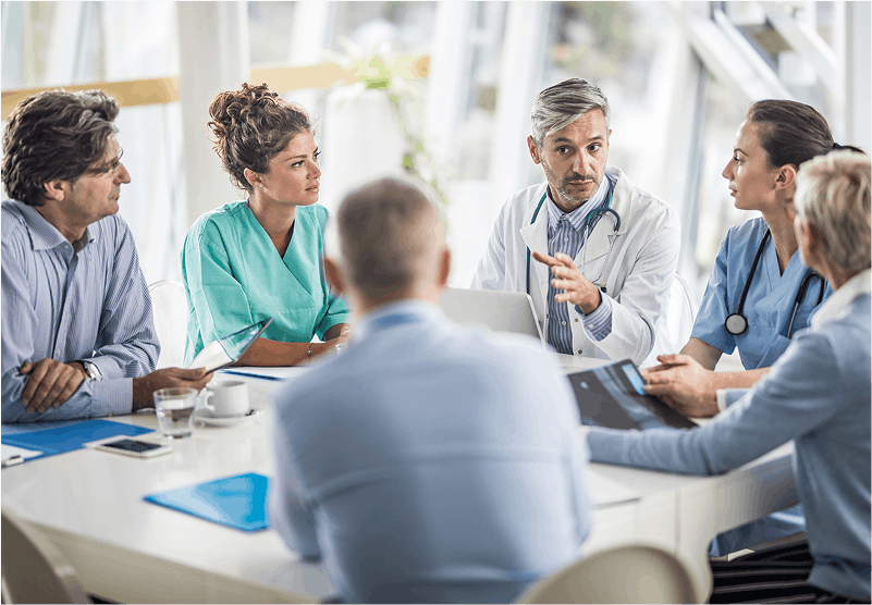 group of medical professionals debriefing around a table in a business setting