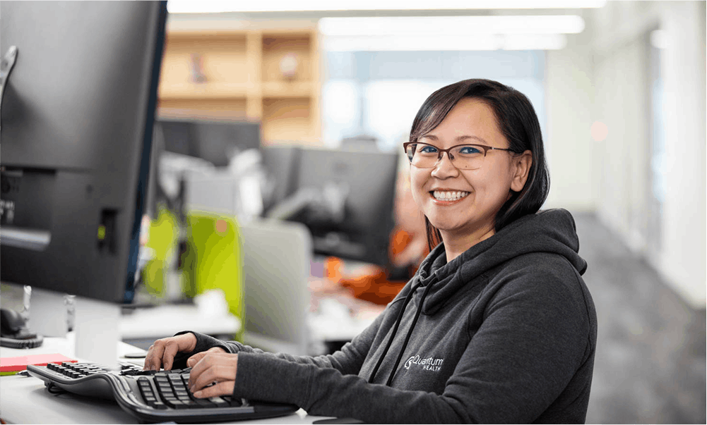 Smiling woman at computer looking at camera
