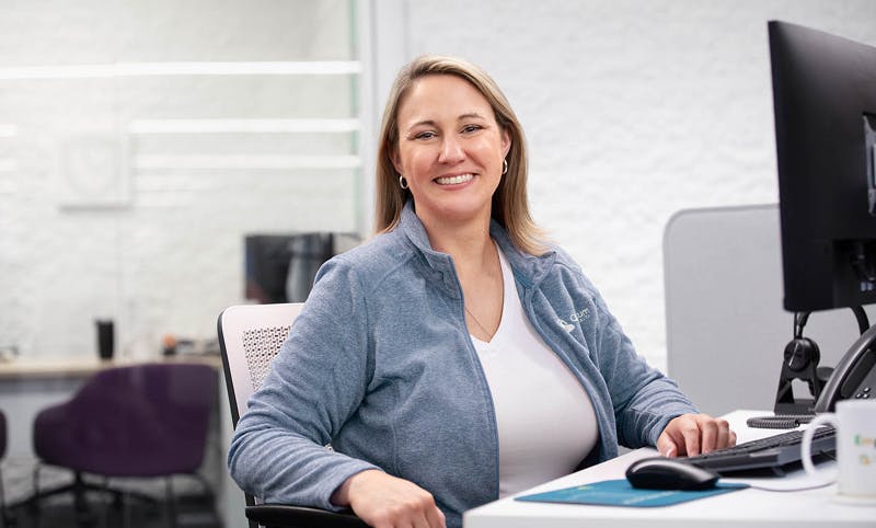 Smiling woman at desk looking at camera