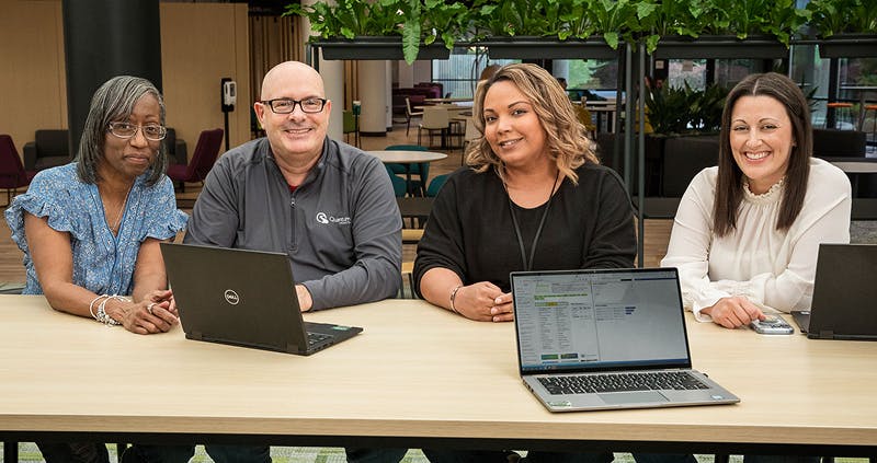 3 women and 1 man smiling at the camera