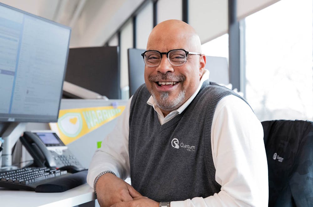 Smiling man at computer looking at camera