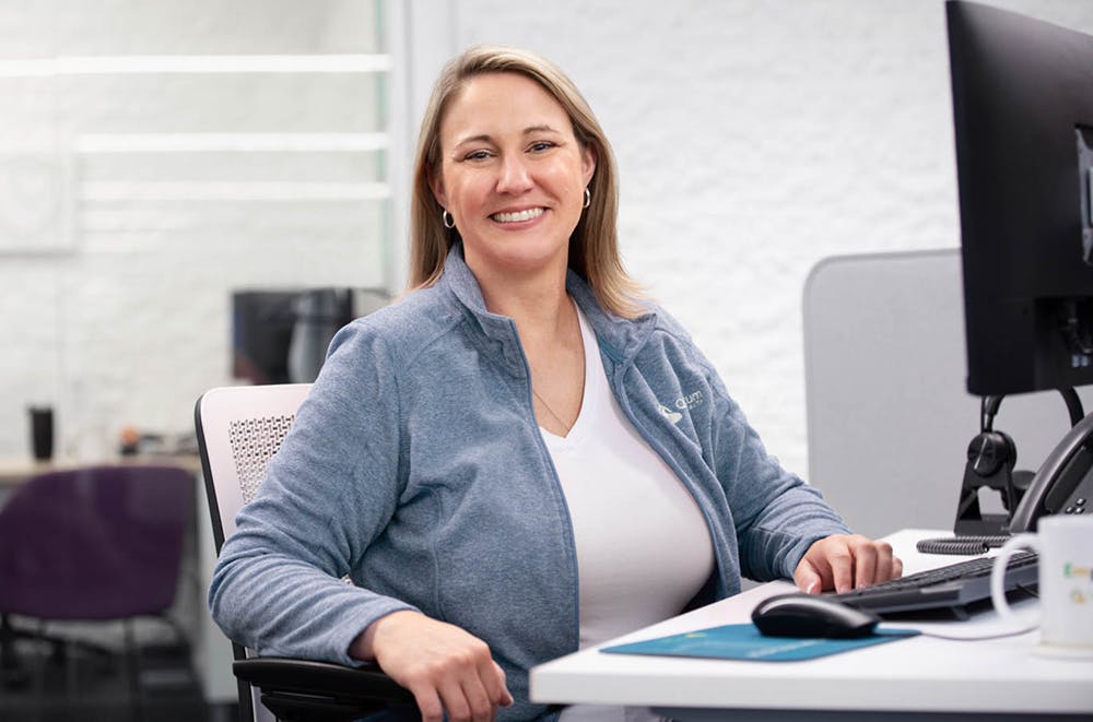Smiling woman at desk looking at camera