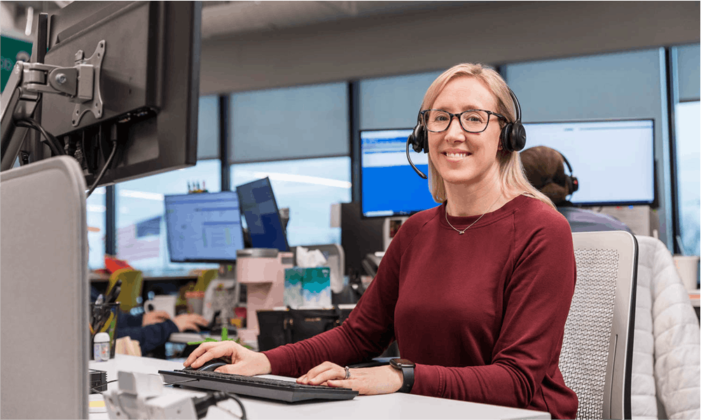 Smiling woman at computer looking at camera