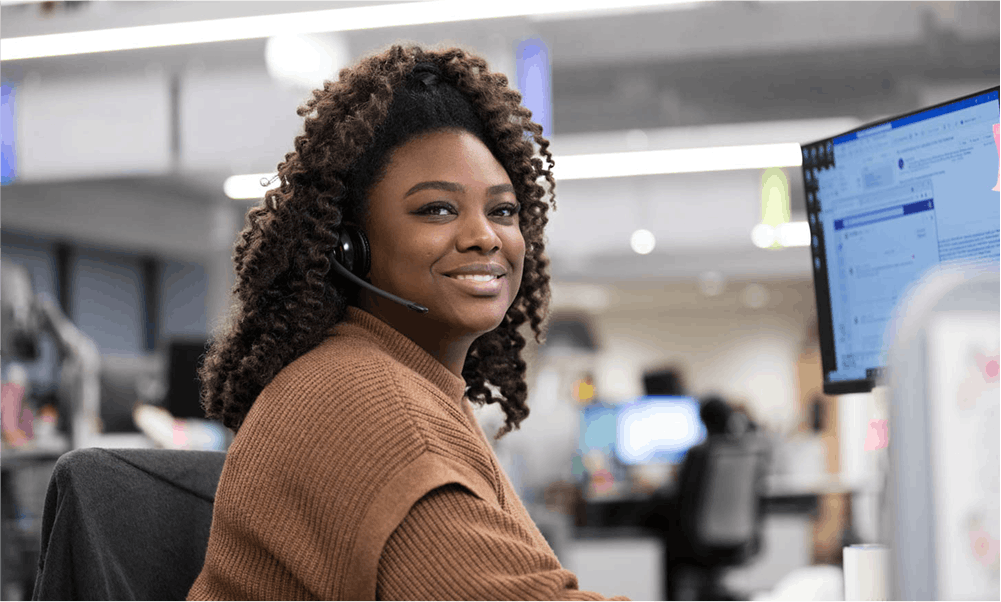 Smiling woman looking at camera at computer
