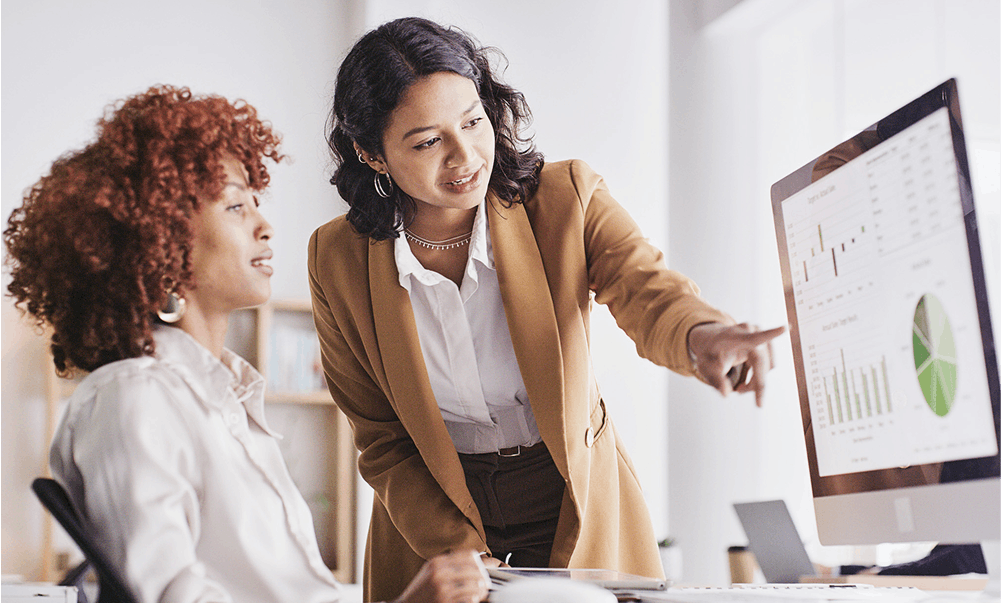 two women looking at a screen with analytics