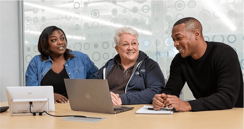 3 pod warriors look at laptop in meeting room