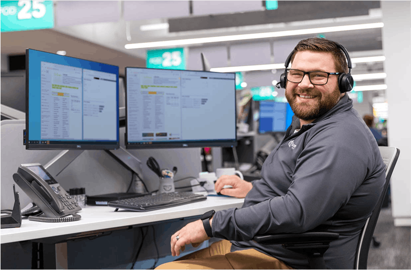 Man smiling at camera in front of computer