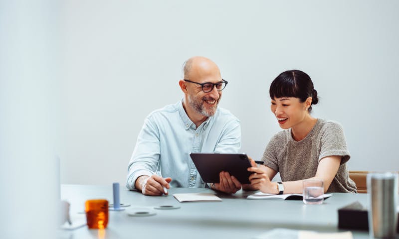 an and woman looking at a screen and smiling