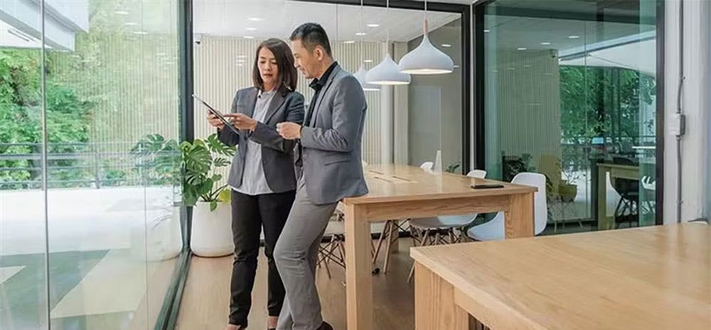Two coworkers looking at a tablet together