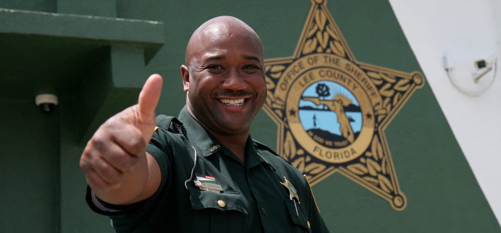 Sheriff giving thumbs up in front of Florida County Sheriff building