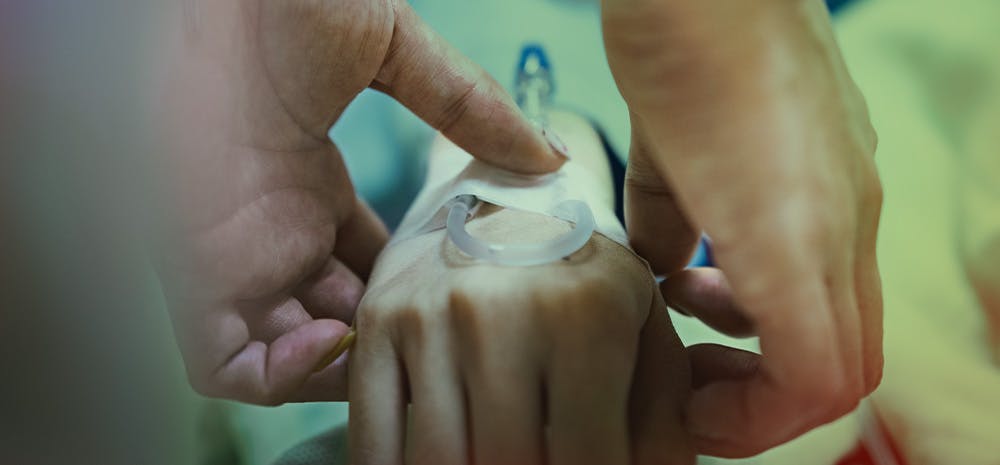 a doctor connecting their patient to an IV. 