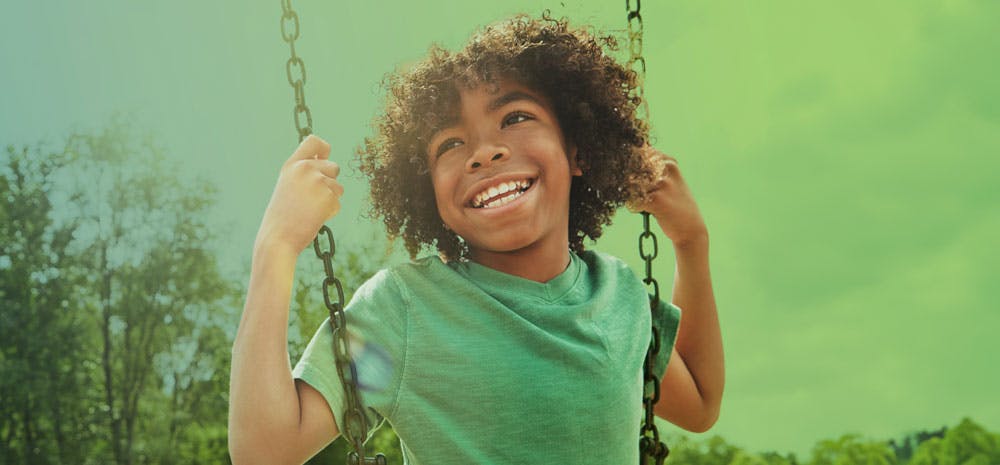 Smiling kid on a swing