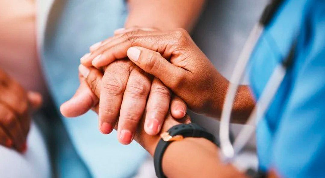 Nurse hands holding a patients hand
