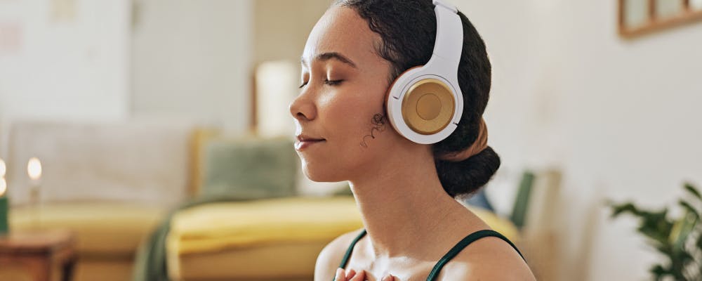 female wearing headphones and meditating