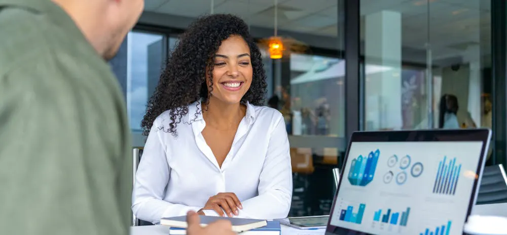 man and woman smiling at analytics on a screen