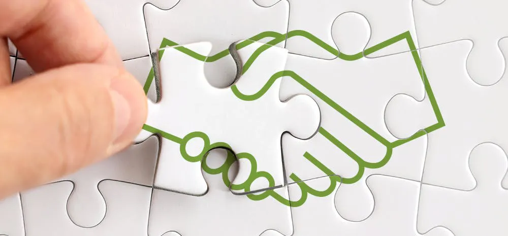 A puzzle piece of two hands shaking