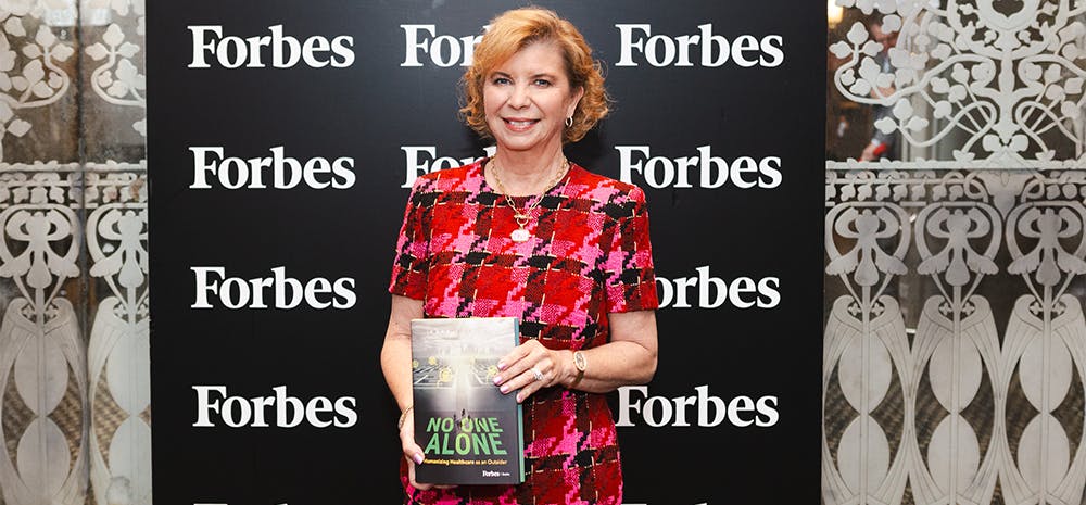 Kara Trott holding her book, No One Alone