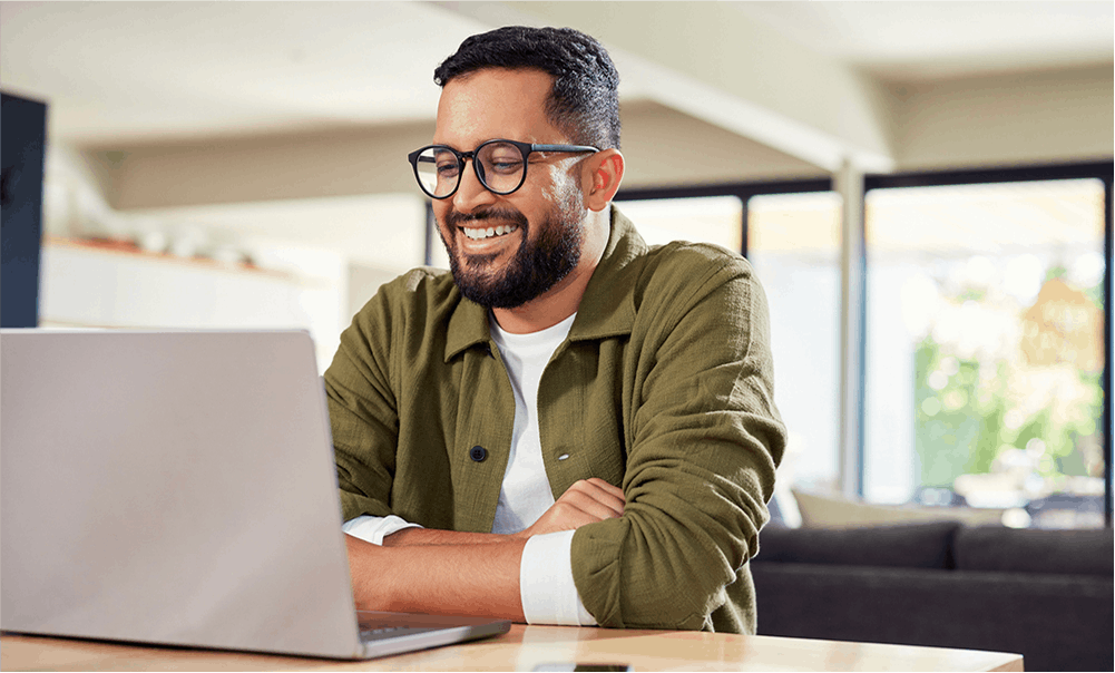 man smiling at a laptop computer