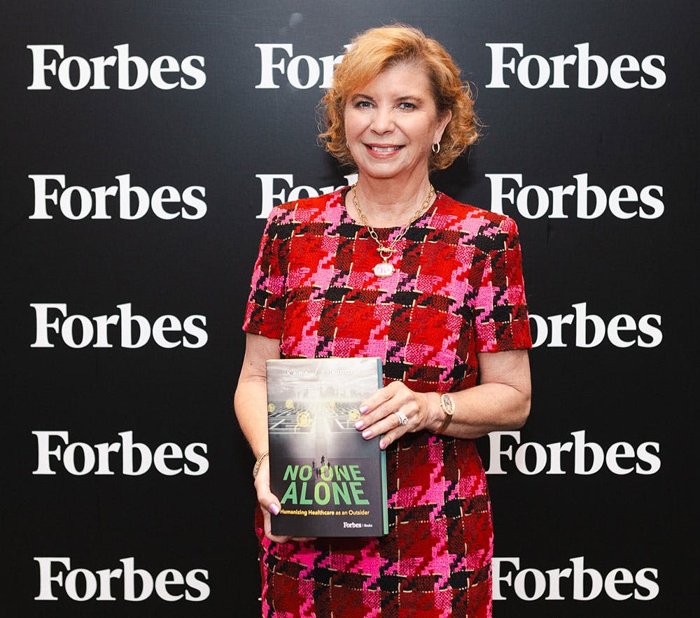 Kara Trott holding No One Alone at Forbes event