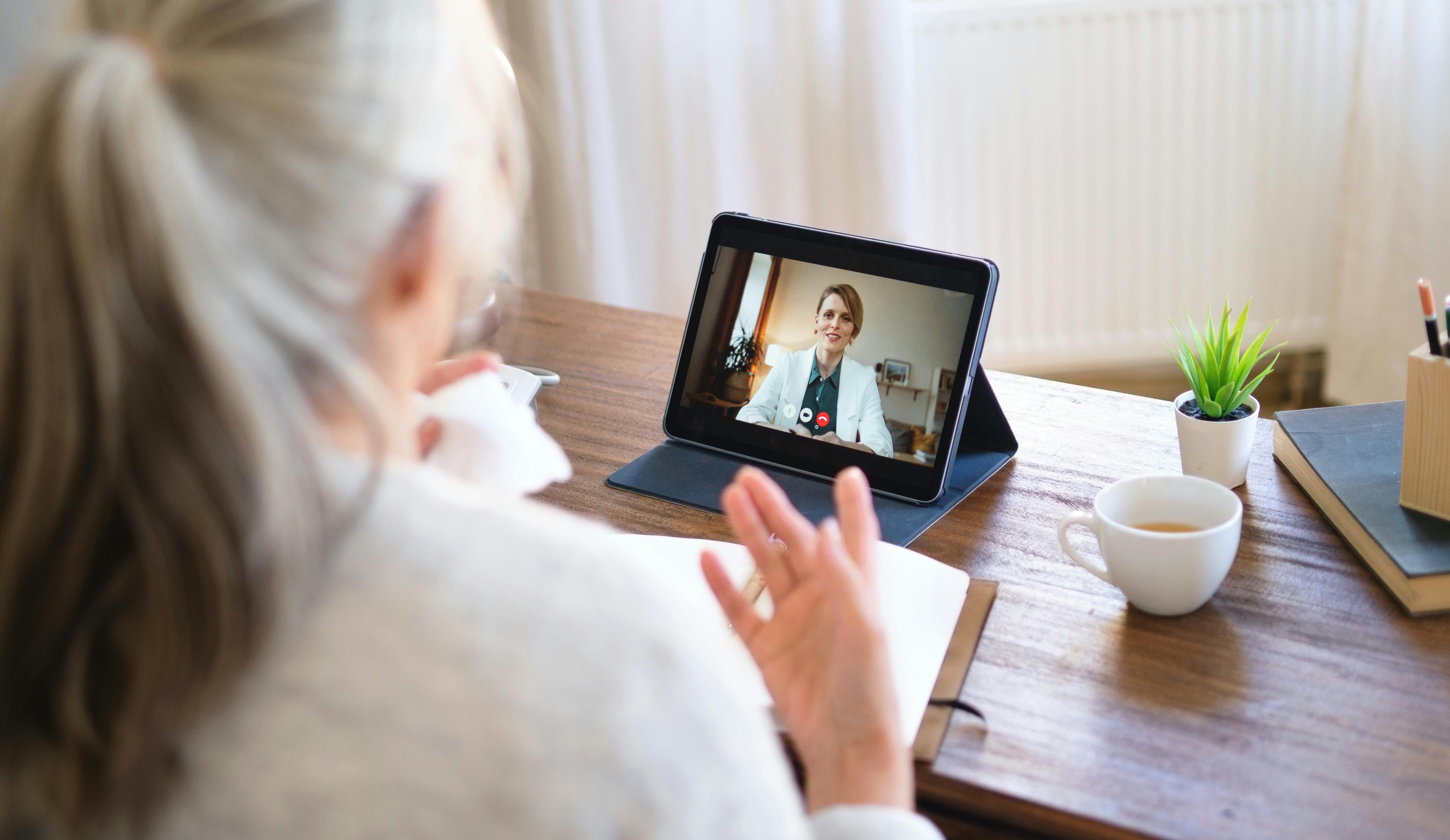 Woman talking to doctor on tablet
