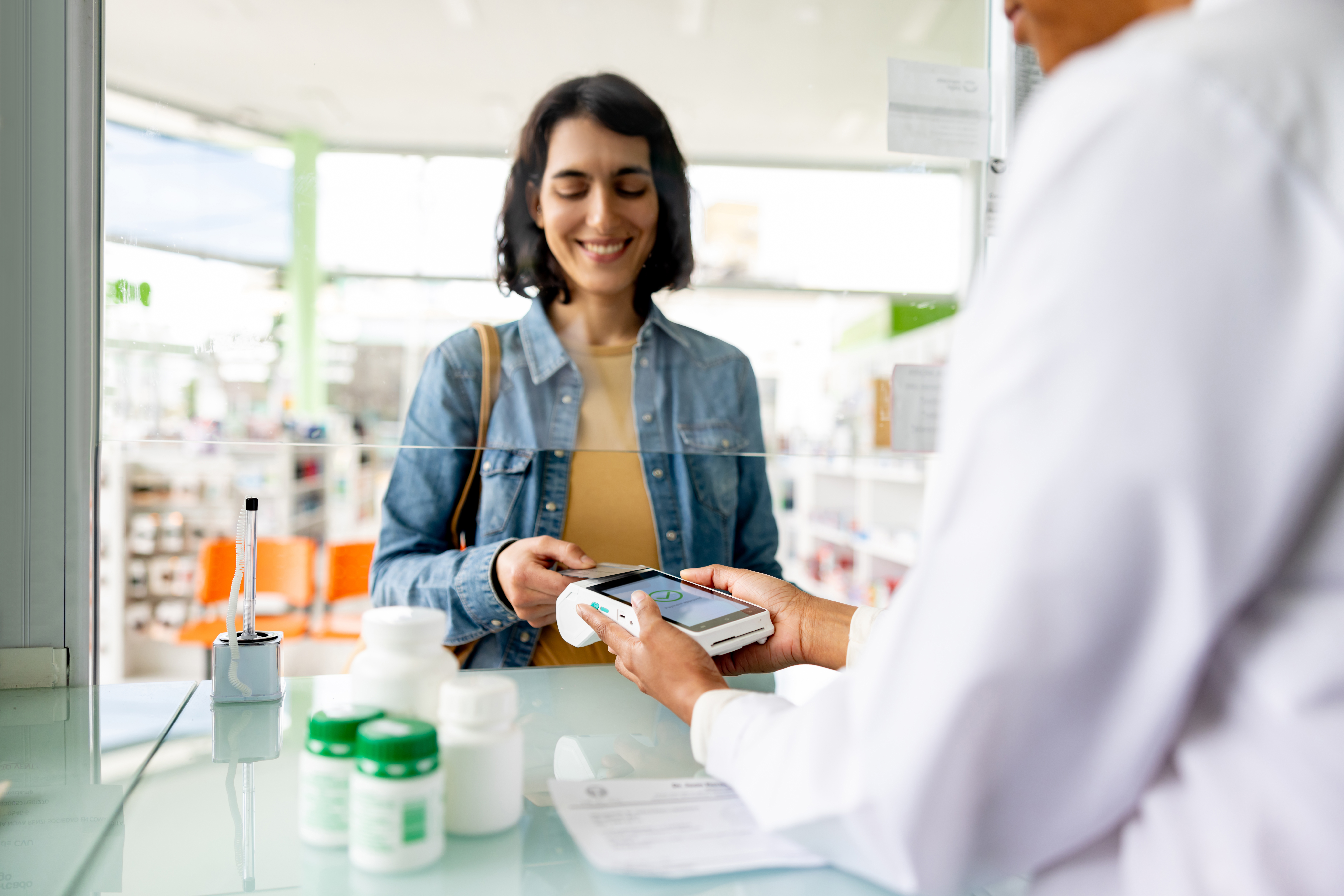 Woman tapping payment card at pharmacy
