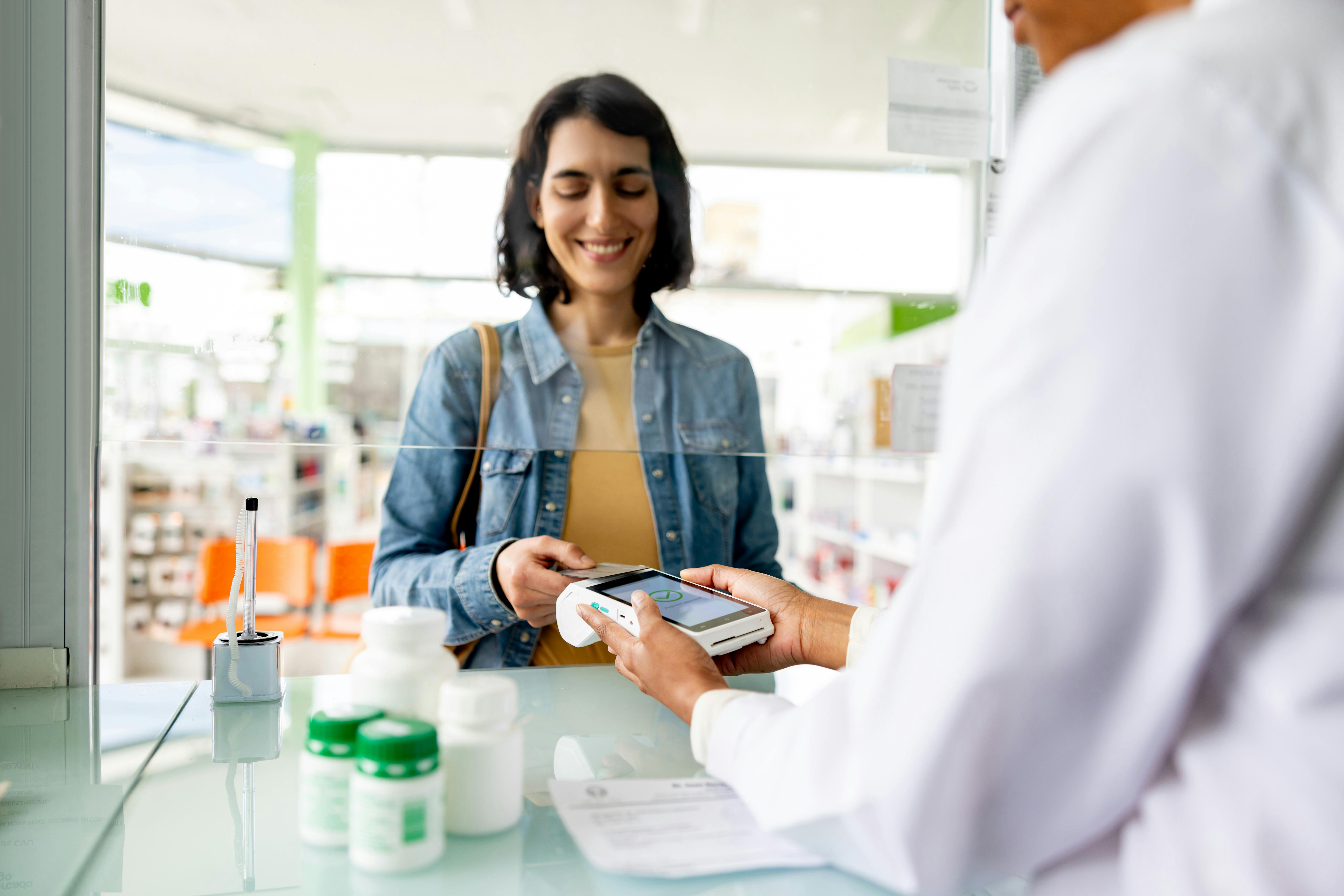 Woman tapping payment card at pharmacy