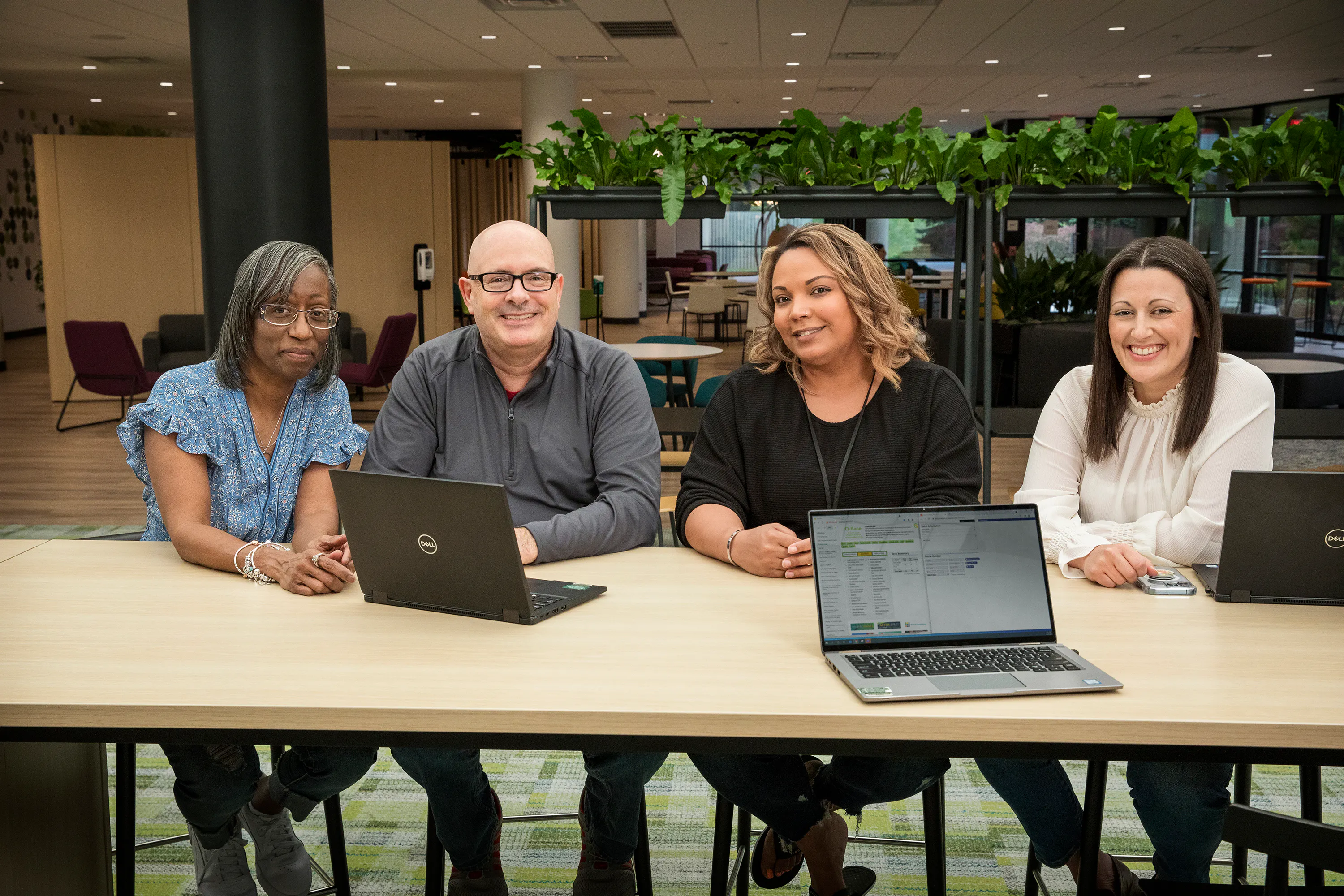 Four Quantum Health employees smiling at camera
