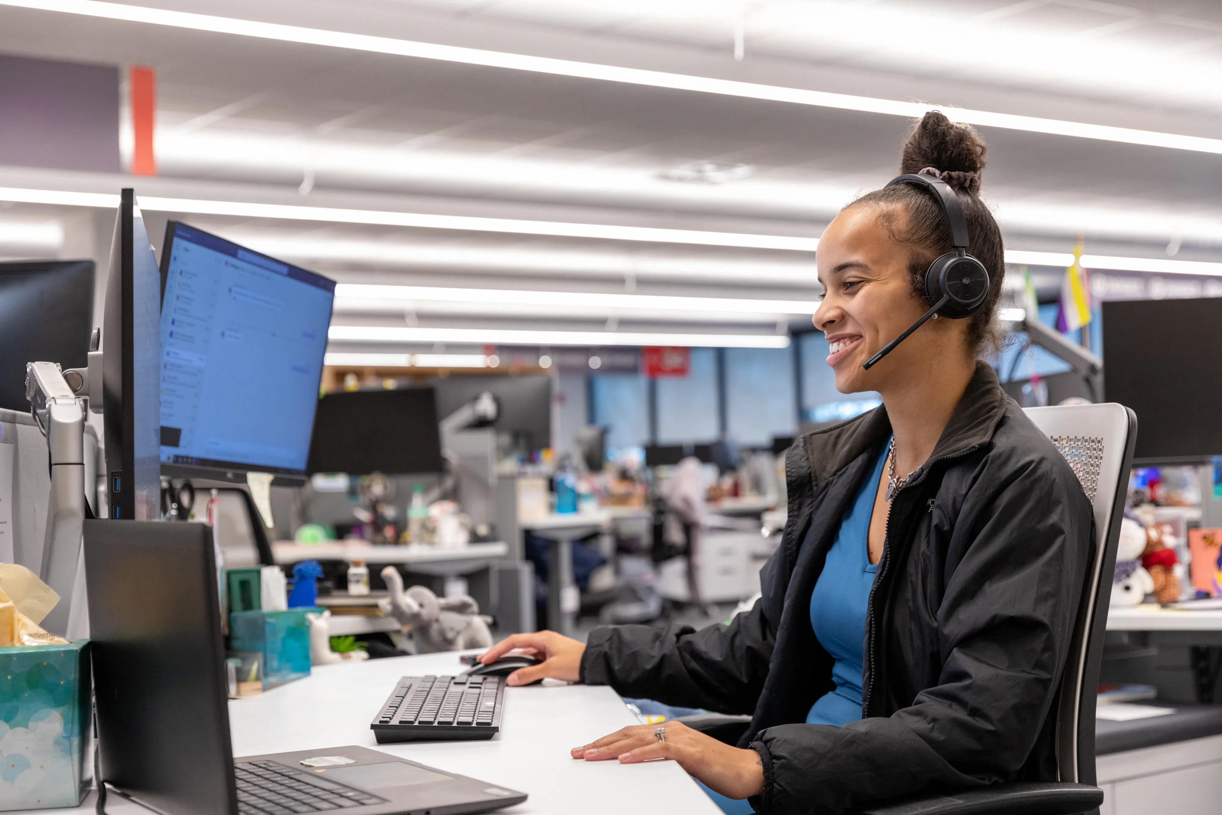 Care Coordinator with headset smiling at desk