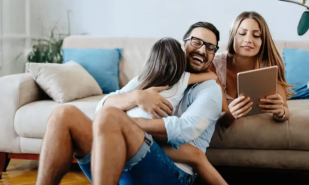 Parents with child smiling on couch