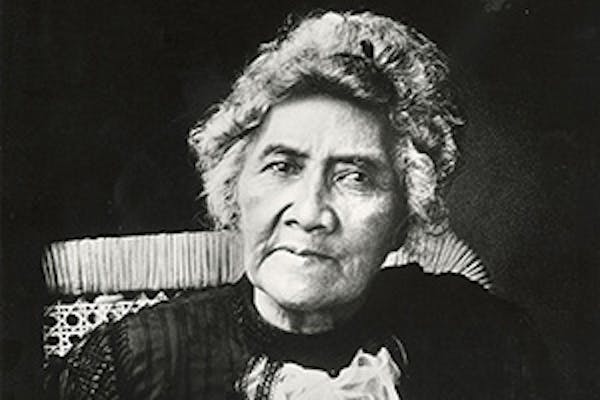 Black and white photo of an older Queen Lili‘uokalani sitting on a chair.