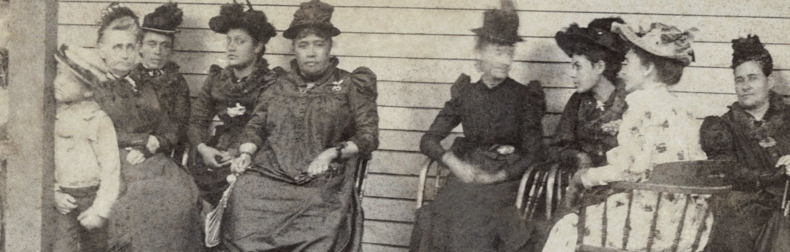 The Queen sitting down with a group of women