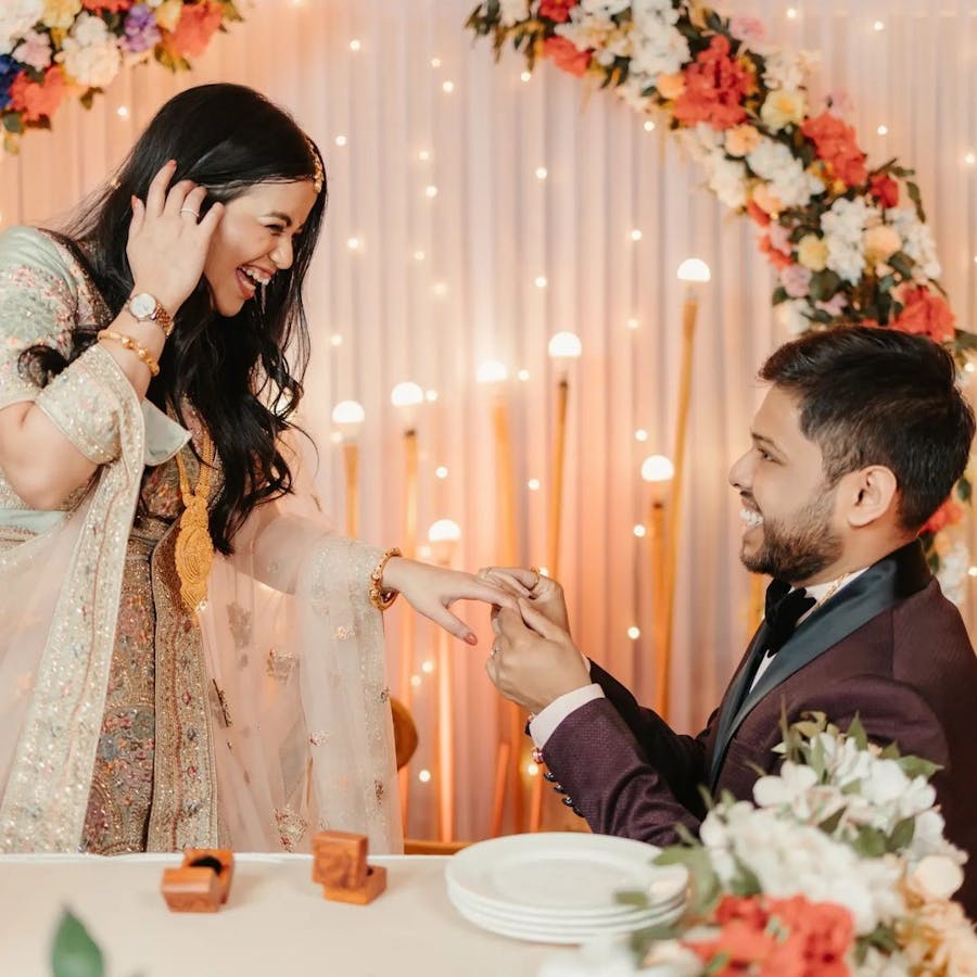 Groom planting a ring on bride's hand