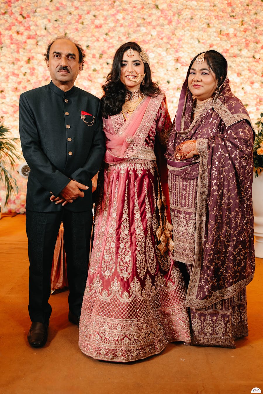 bride posing with parents pic