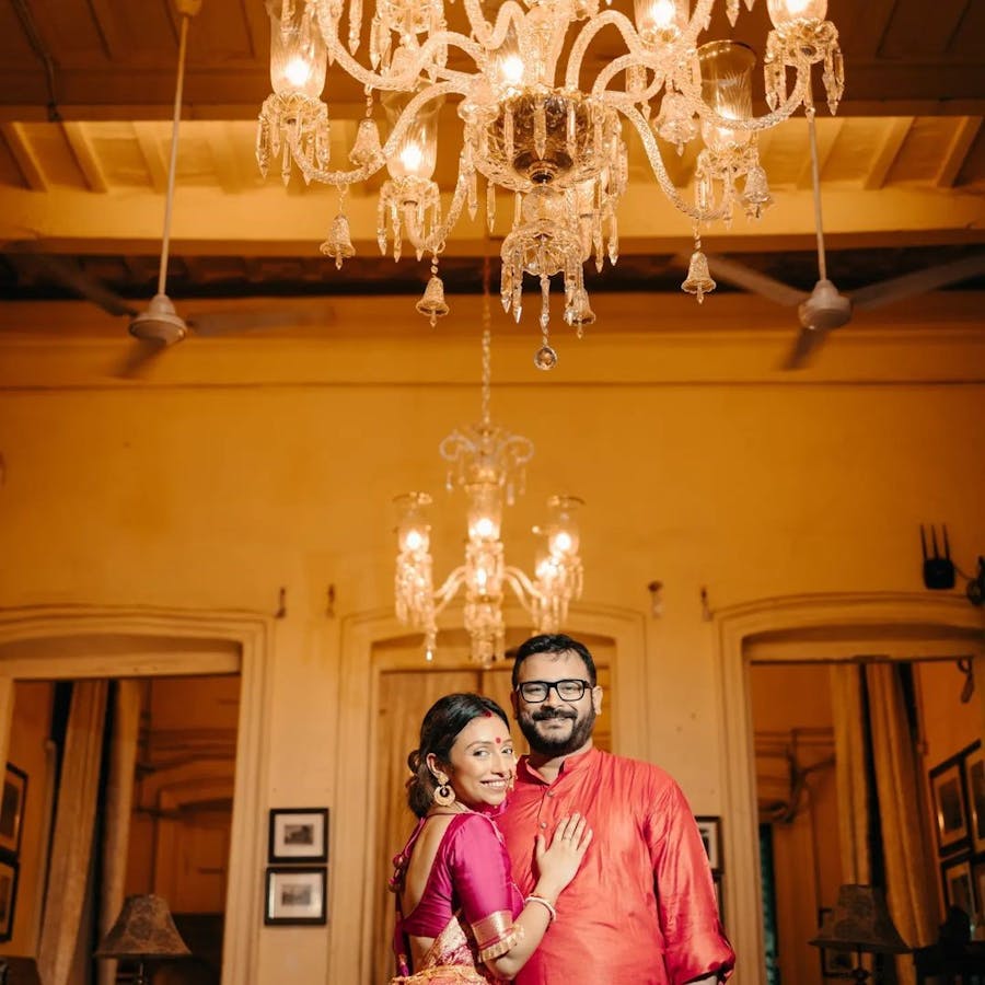 Couple posing under a chandelier