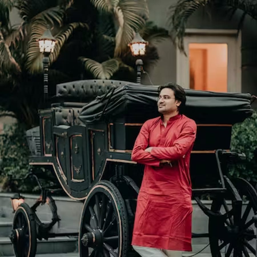 Groom posing against a carriage