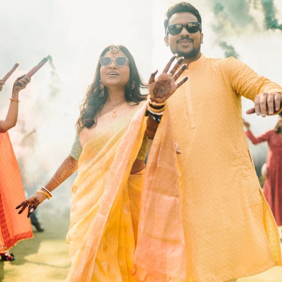 Couple dancing in their reception in yellow outfits