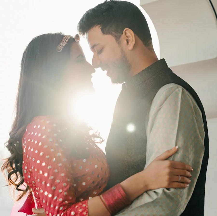 Couple holding a pose with sun rays in between