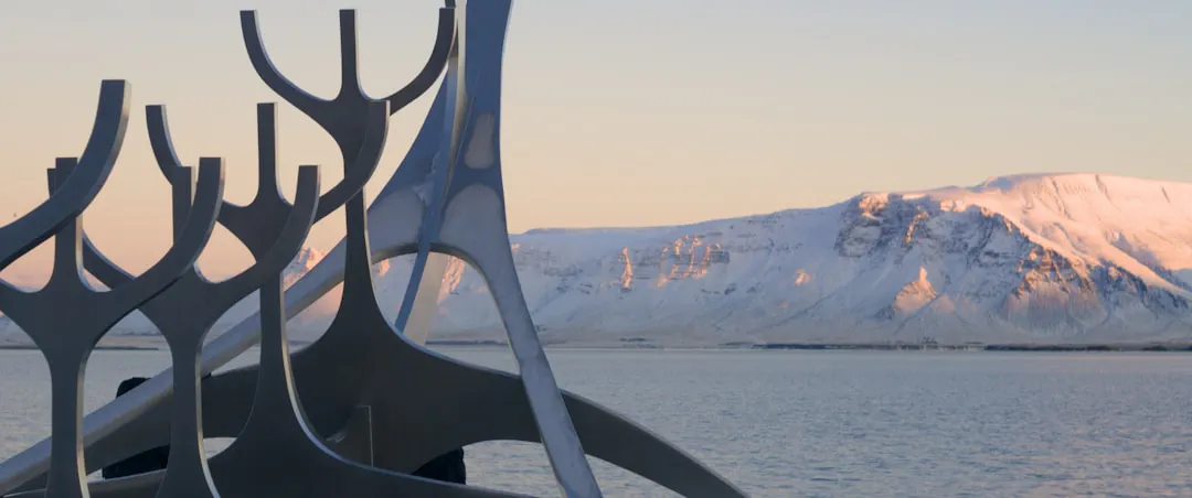 A sculpture against a mountain and sea backdrop.