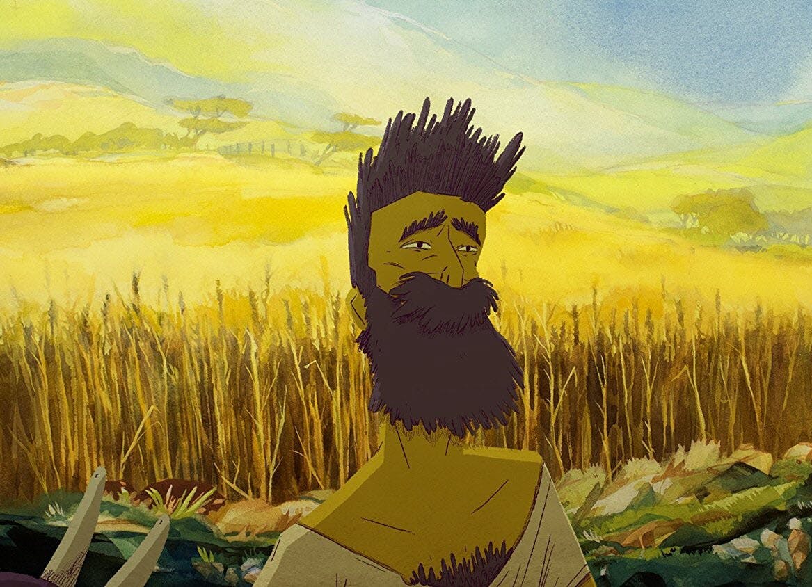 A bearded man stands in front of wheat fields in autumn.