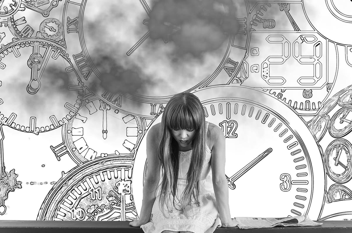 A young woman sitting before a wall of clocks