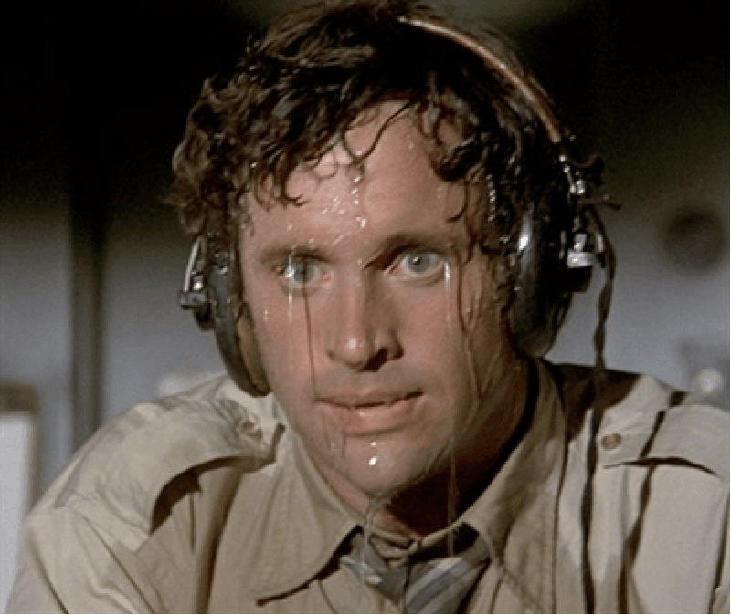 Military man, with curly hair, blue eyes, wearing headphones, that sweats  