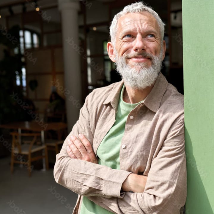 Man leaning up a green door smiling