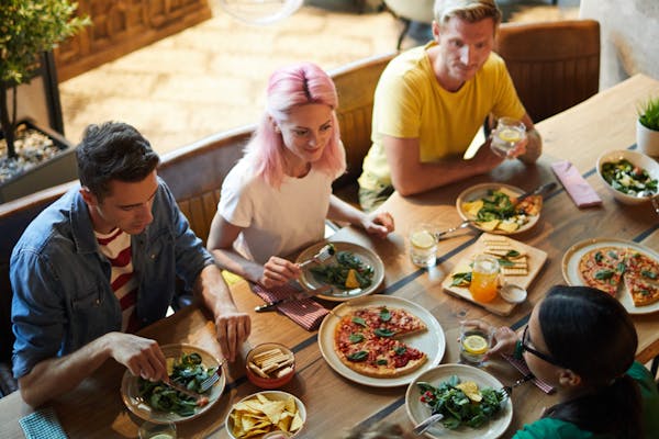 A group of people sat round a table having lunch