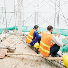 two builders eating lunch at a worksite