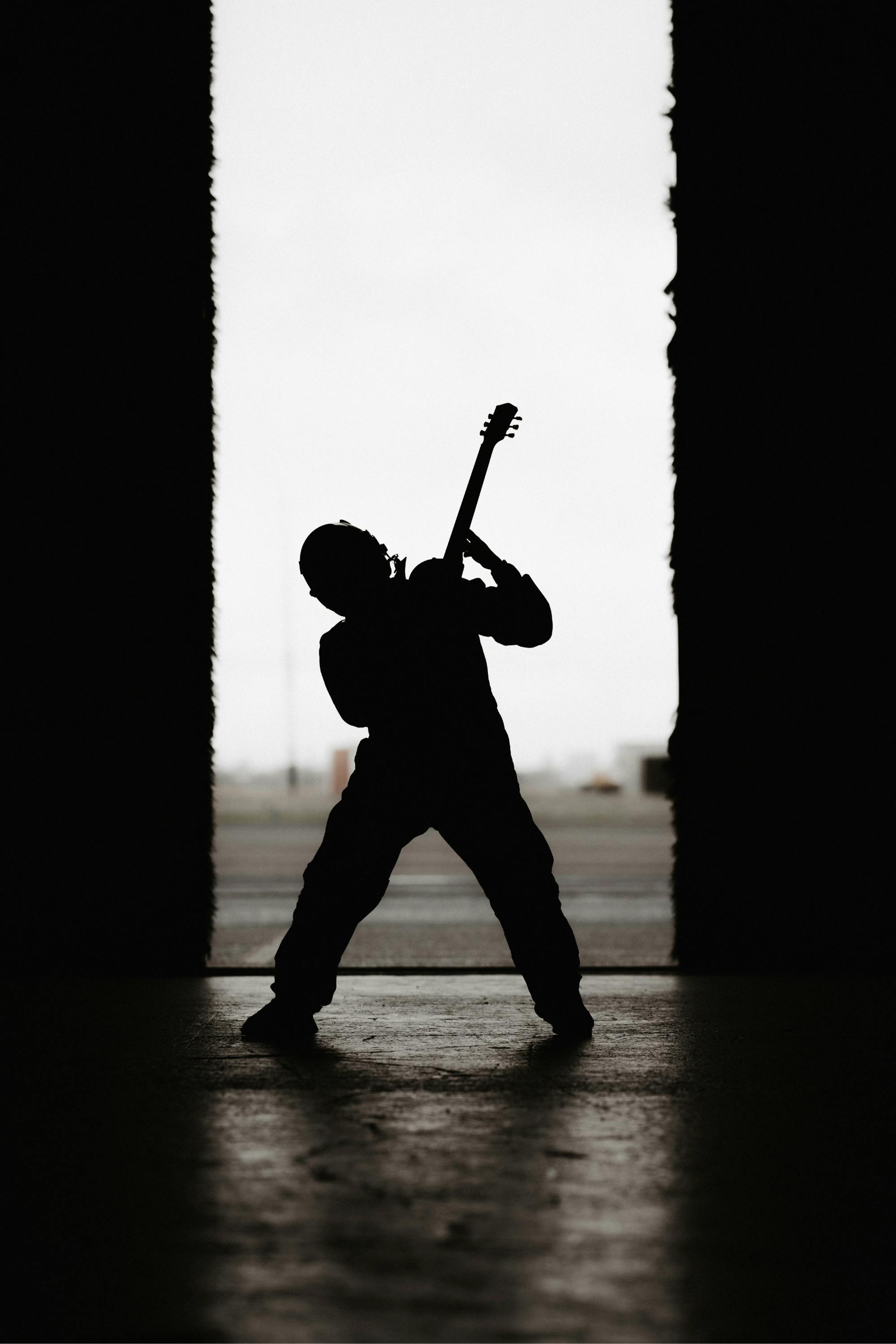 Pilot playing guitar in air hanger