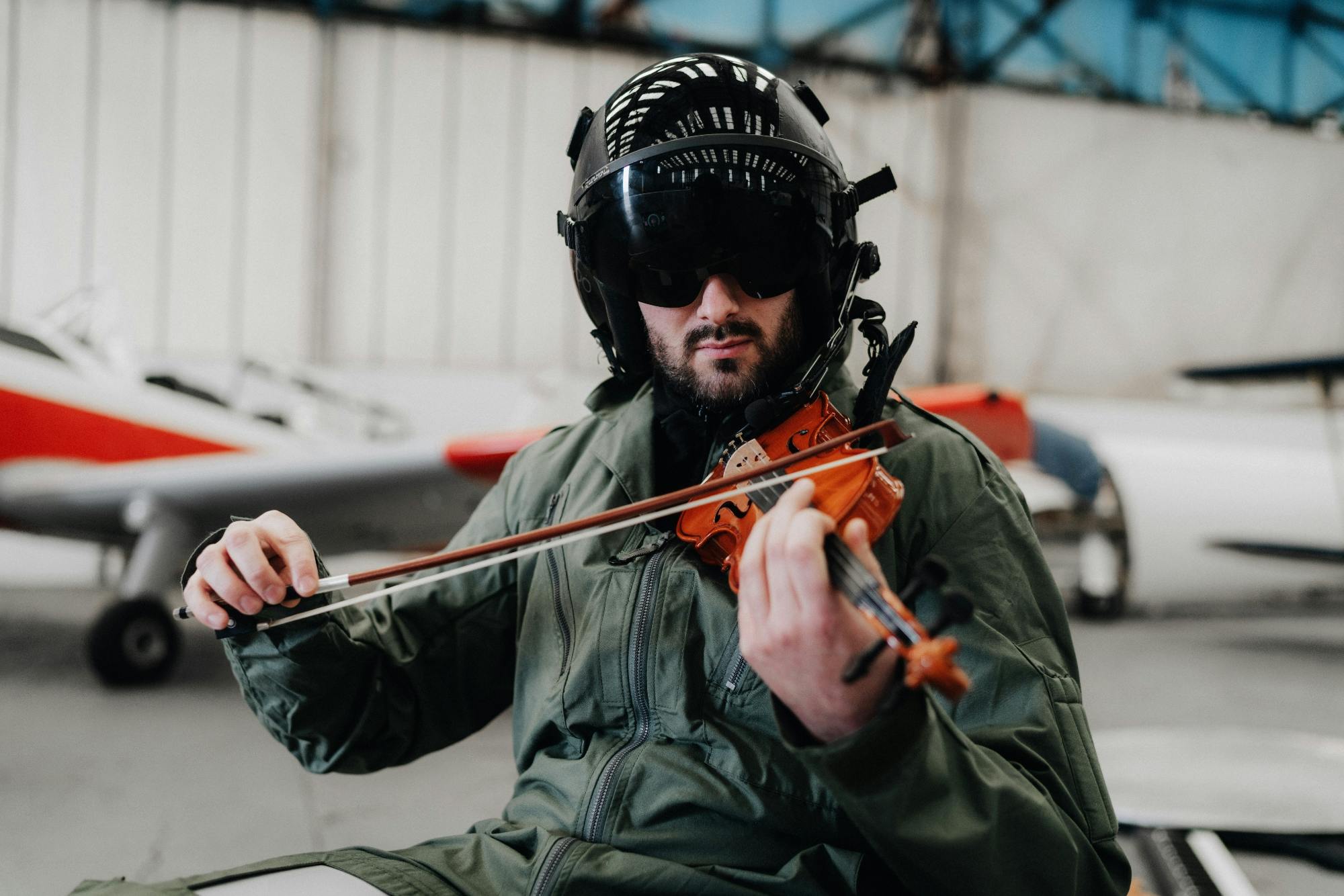 Pilot playing violin in air hanger