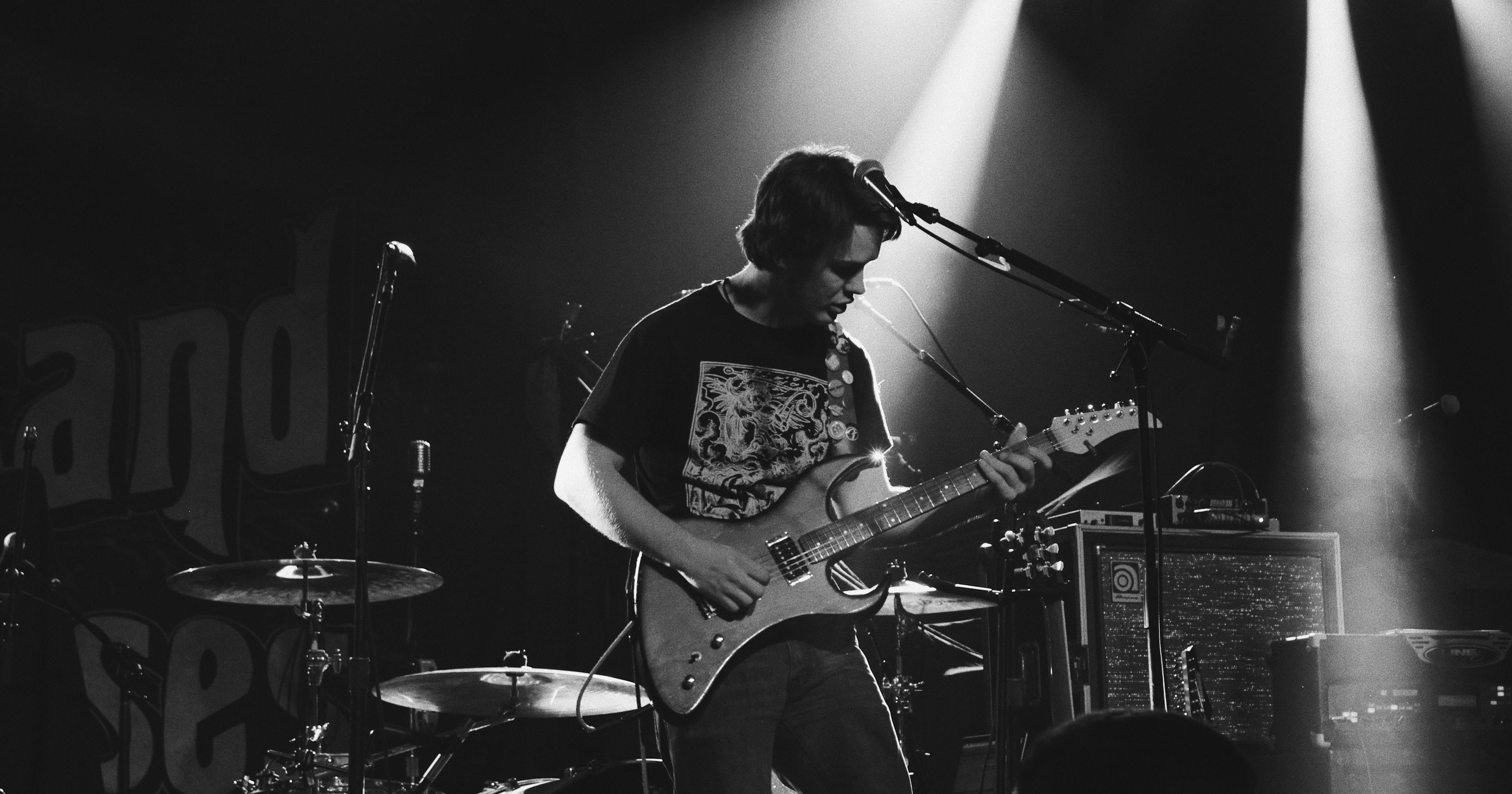 man playing guitar live on stage