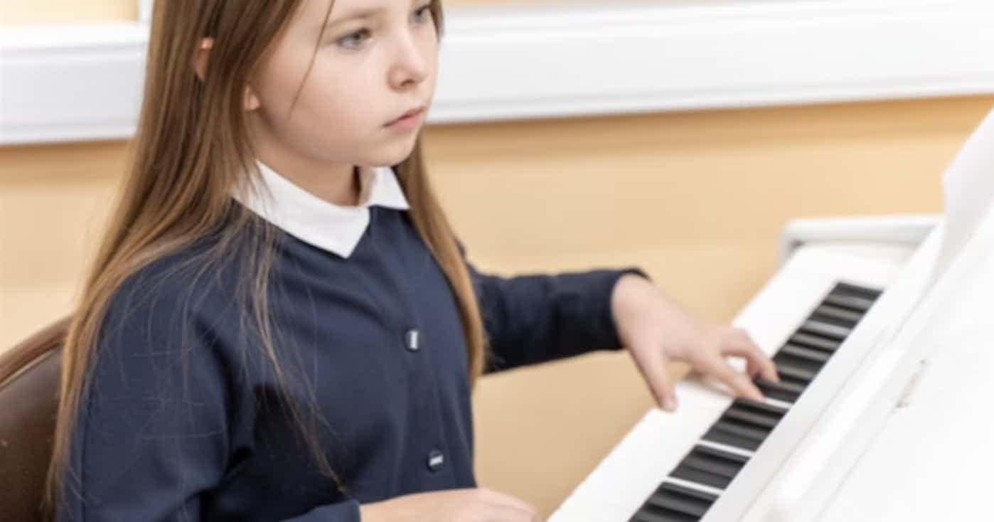 girl learning to play the piano